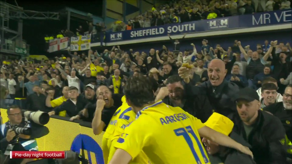 a group of soccer players are celebrating in front of a sign that says sheffield south