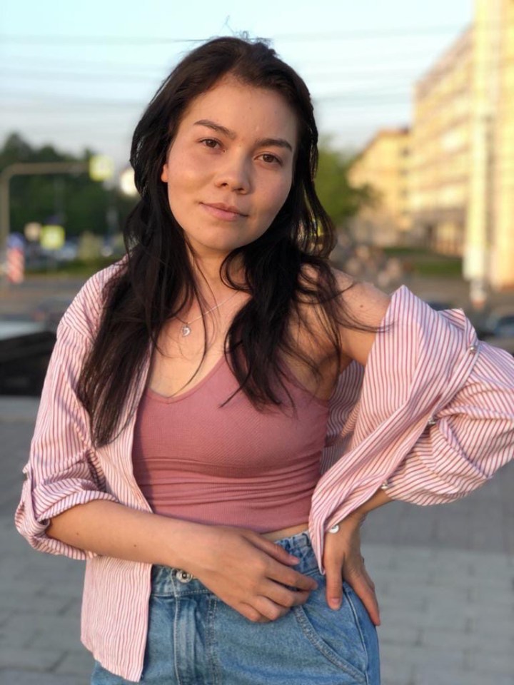 a woman wearing a pink tank top and a striped shirt