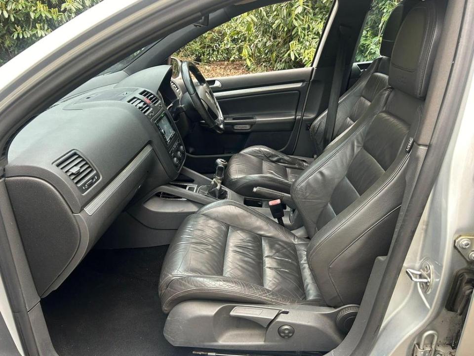 the interior of a silver car with black leather seats