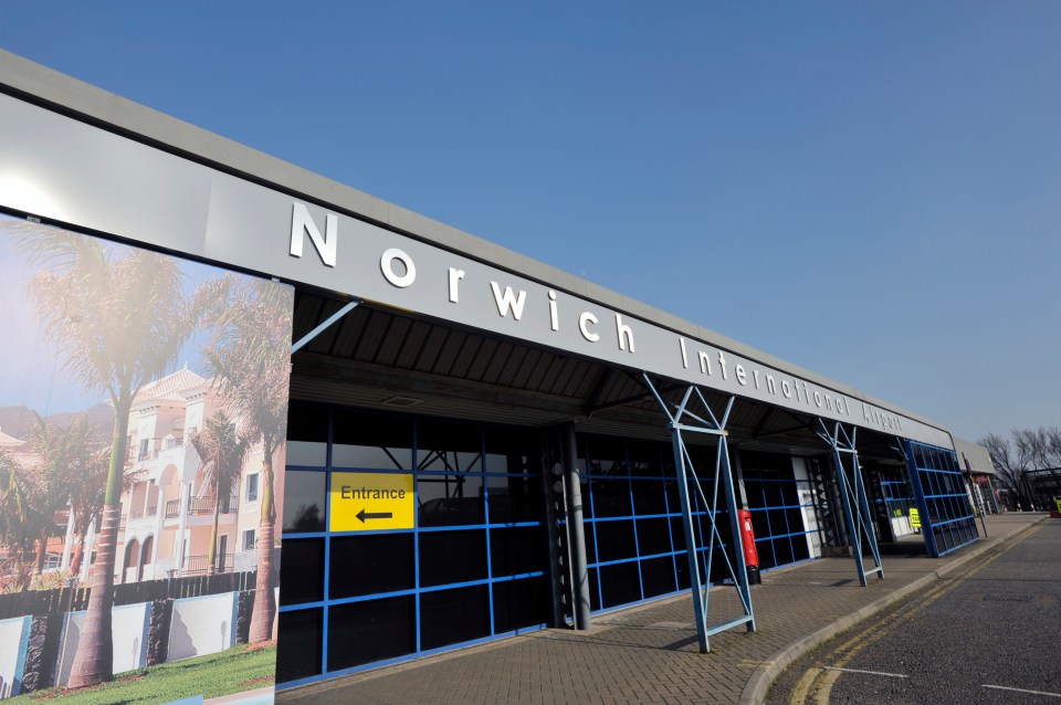 norwich international airport has a yellow sign pointing to the entrance