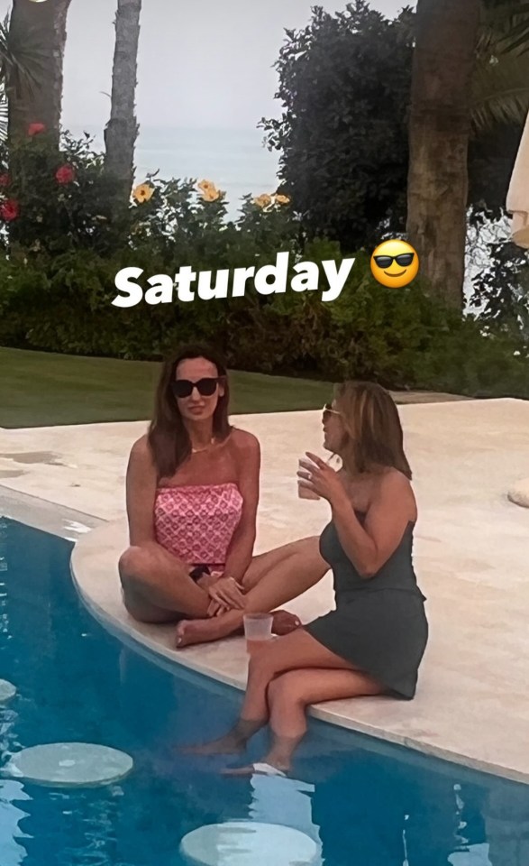 two women sit on the edge of a swimming pool on saturday