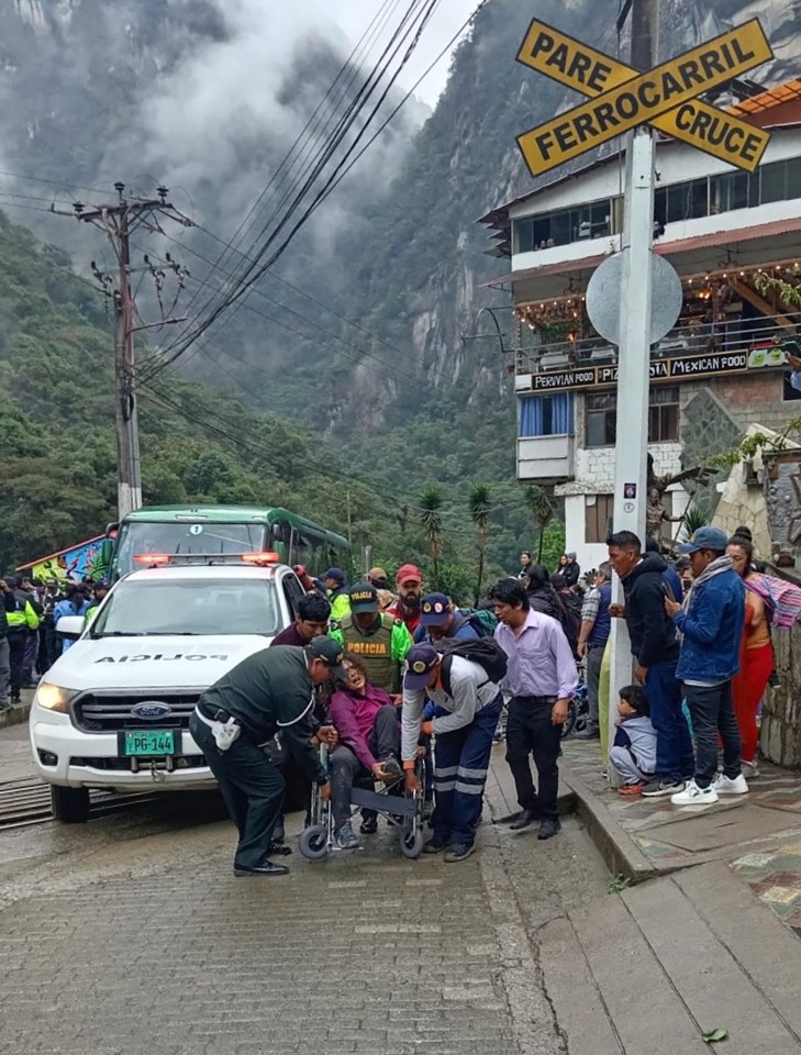 a man in a wheelchair is being helped by a group of people in front of a sign that says pare ferrocarril cruce