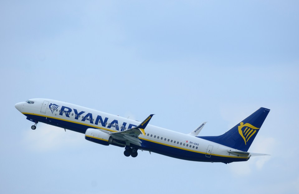 a ryanair plane is flying through the air