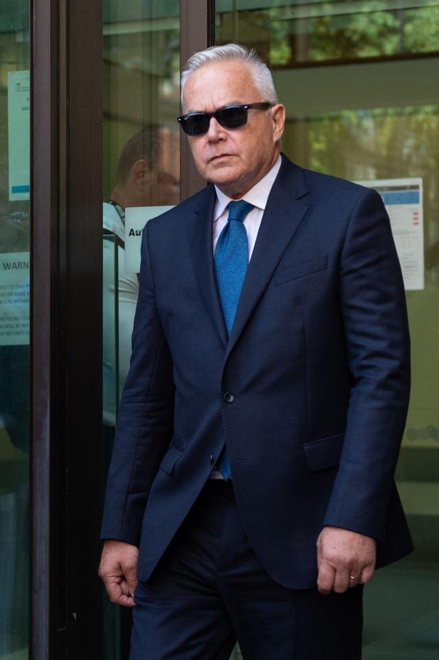 a man in a suit and tie stands in front of a sign that says warning
