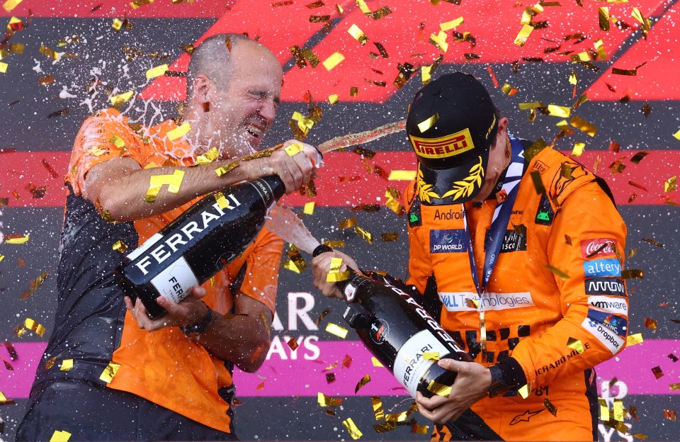 two men are holding bottles of ferrari champagne