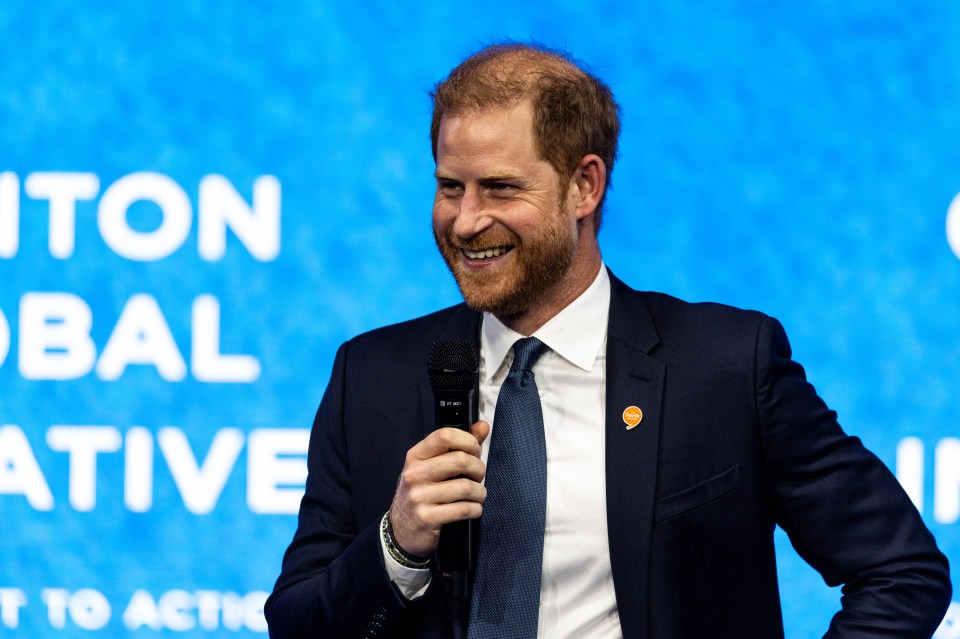 a man in a suit and tie is smiling while holding a microphone
