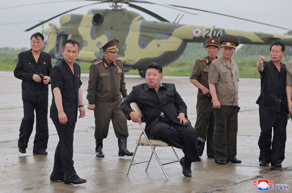 a group of men are standing in front of a helicopter with the number 204 on it