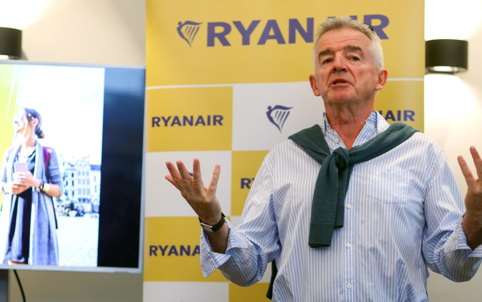 a man stands in front of a ryanair banner