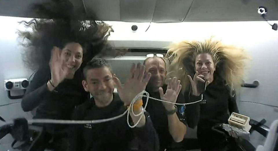 a group of people are waving while wearing nasa shirts