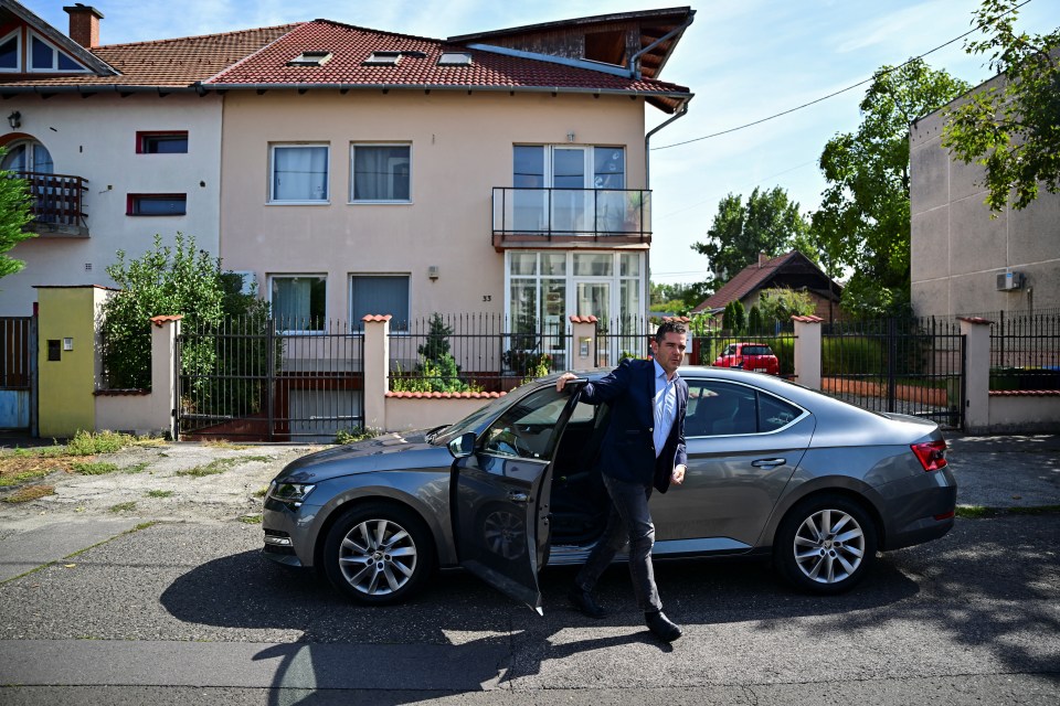 a man getting out of a car in front of a house