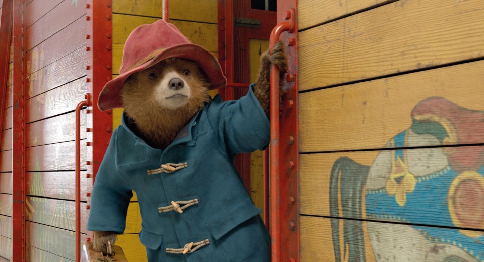 a teddy bear wearing a red hat and a blue coat