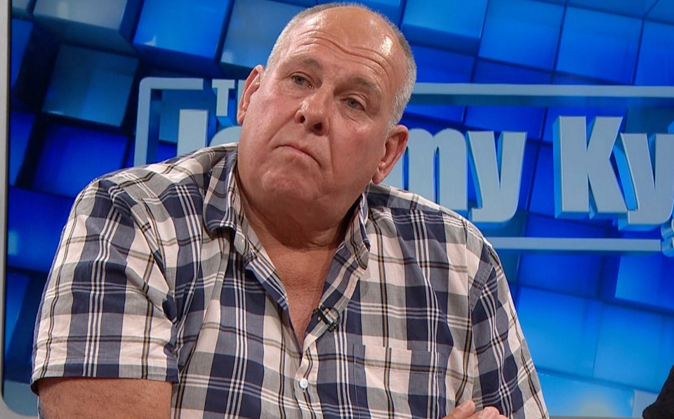 a man in a plaid shirt sits in front of a sign that says my ky