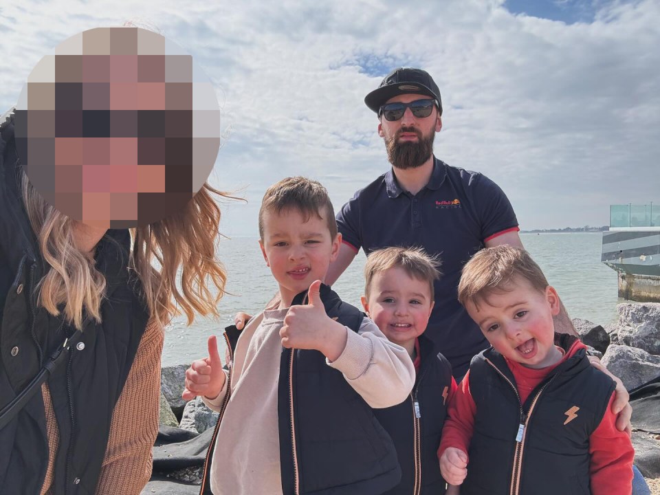 a man wearing a red bull shirt poses with his family