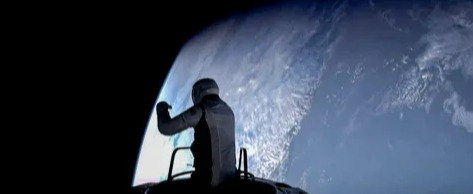 a man is standing on top of a rocket in space looking at the earth .