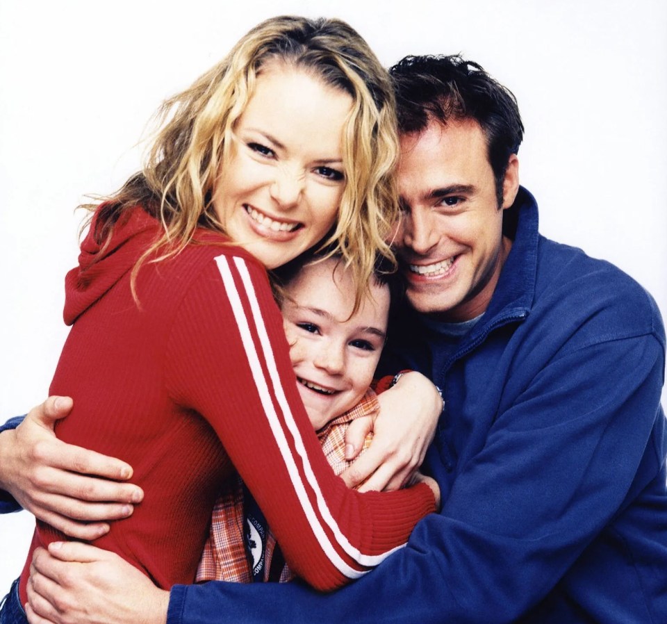 a woman in a red sweater is hugging a boy in a blue jacket