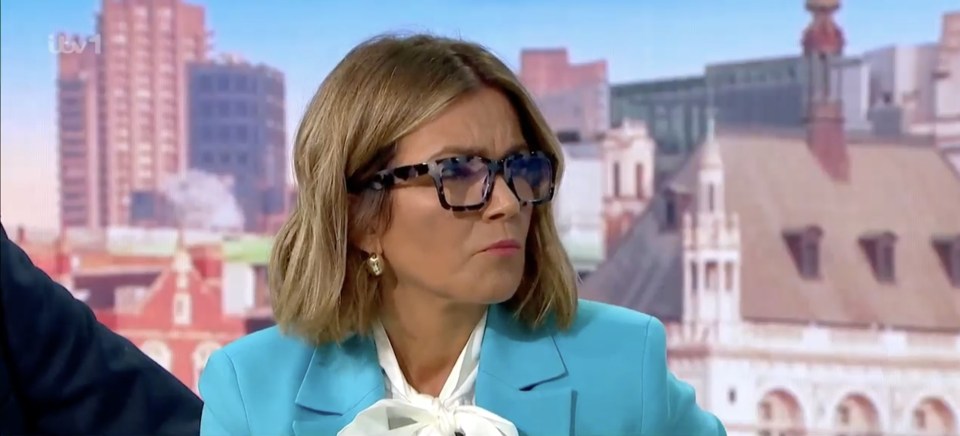 a woman wearing glasses and a blue jacket is on a news channel
