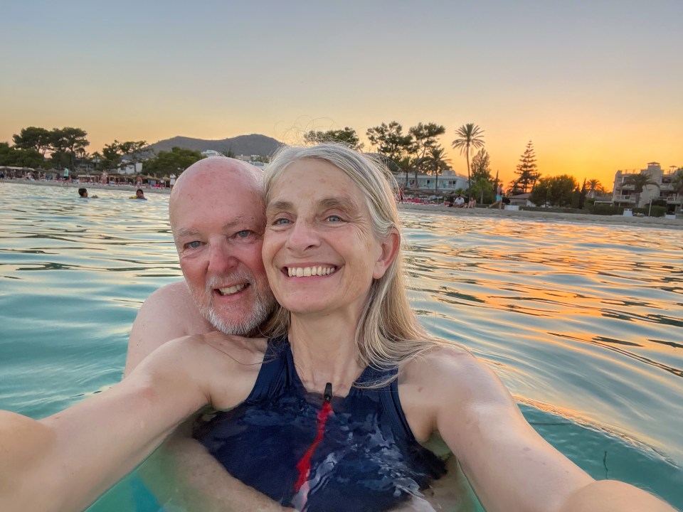 a man and woman are posing for a picture in the water