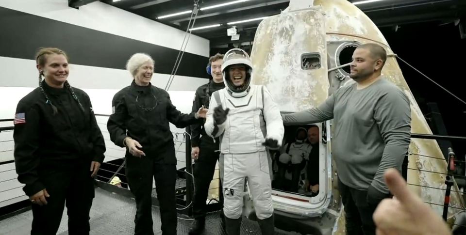 a group of people are standing in front of a space ship