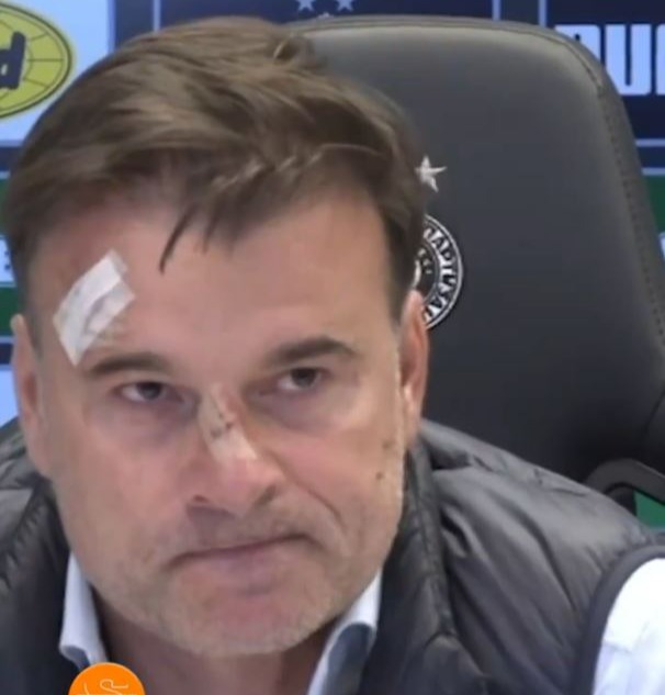 a man with a bandage on his forehead sits in a chair