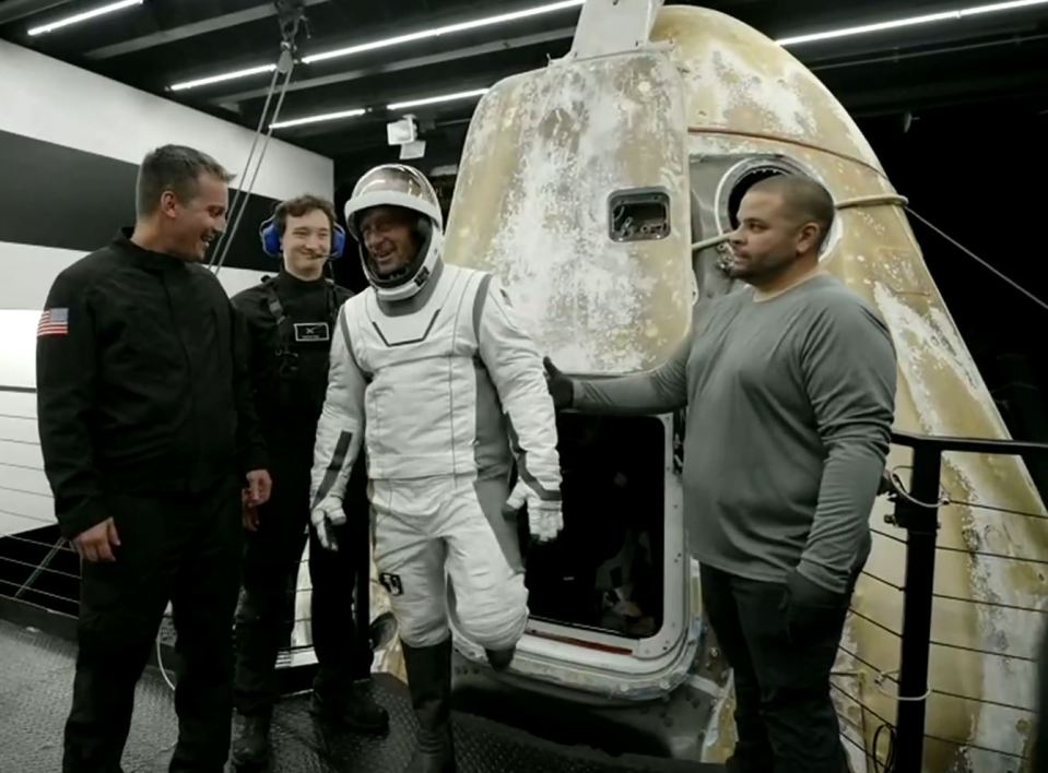 a man in a space suit has the letter c on his chest
