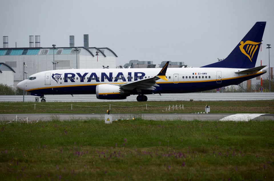 a ryanair plane sits on a runway in front of a building