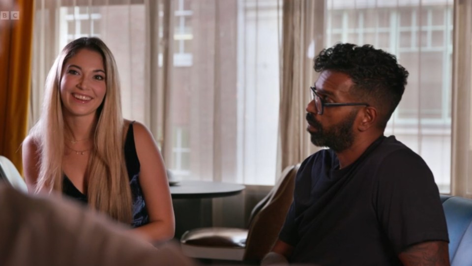 a man and a woman are sitting in front of a window with bbc on the bottom right