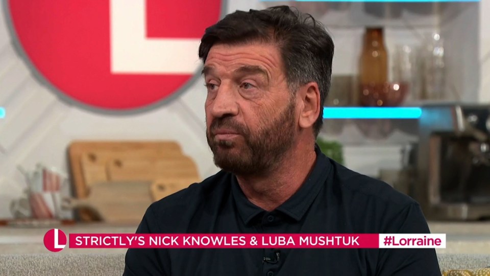 a man with a beard is sitting on a couch in front of a sign that says strictly 's nick knowles