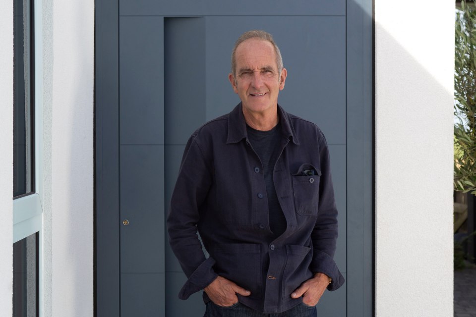 a man standing in front of a door with his hands in his pockets