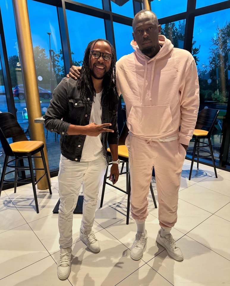 a man in a pink hoodie stands next to another man