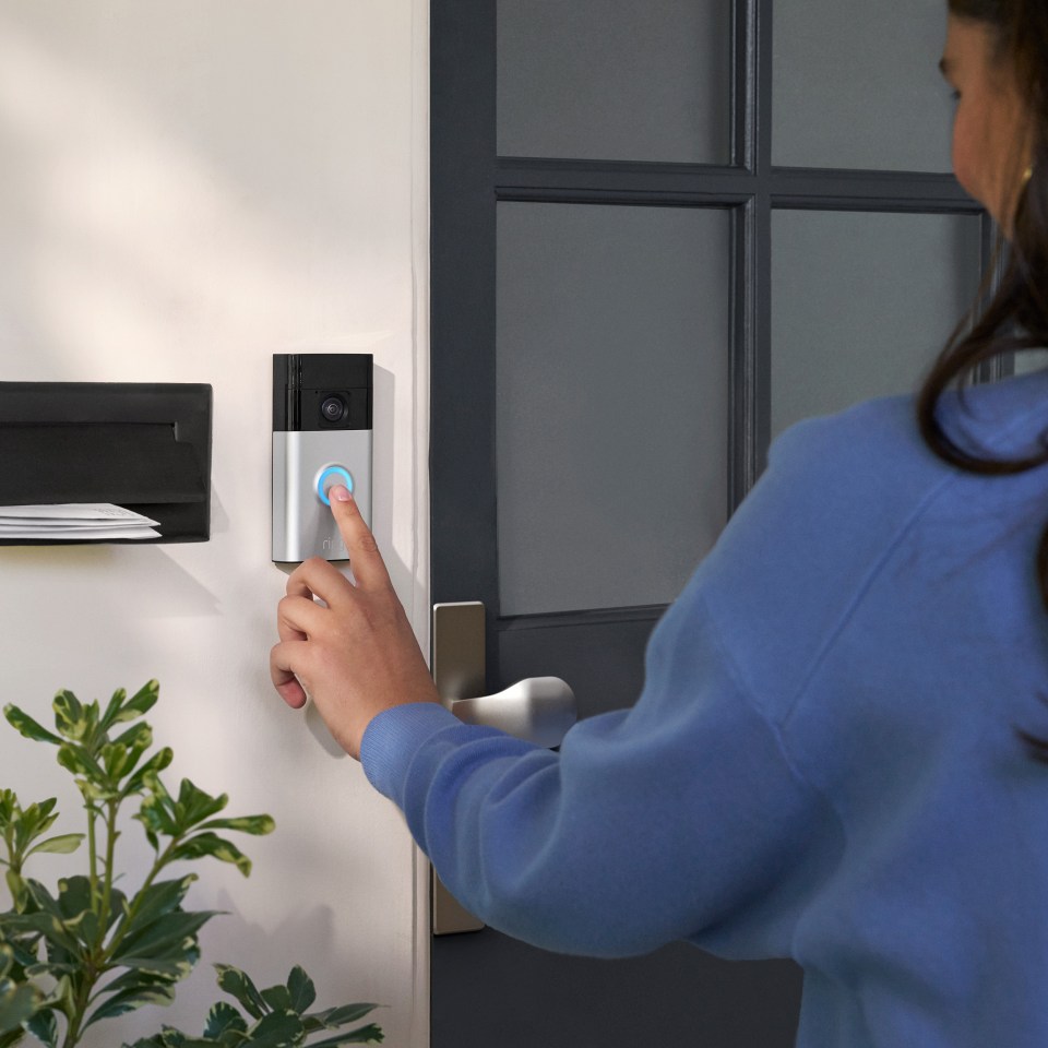 a person pressing a button on a ring doorbell