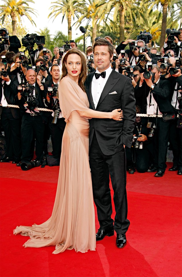 a man and woman are posing for a picture on a red carpet