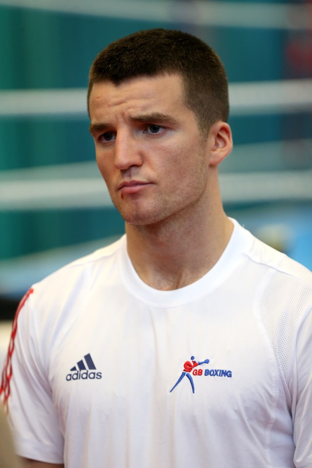 a man wearing an adidas shirt with gb boxing on it