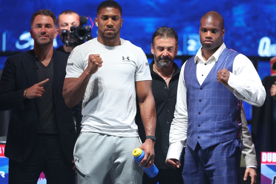 a man in a white under armour shirt stands next to two other men