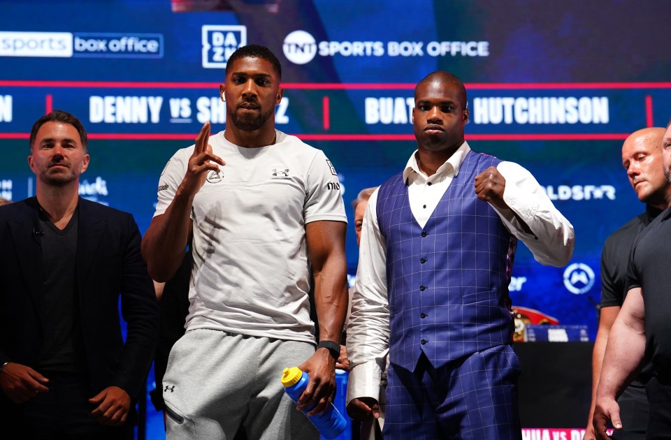 a man in a white under armour shirt stands next to two other men