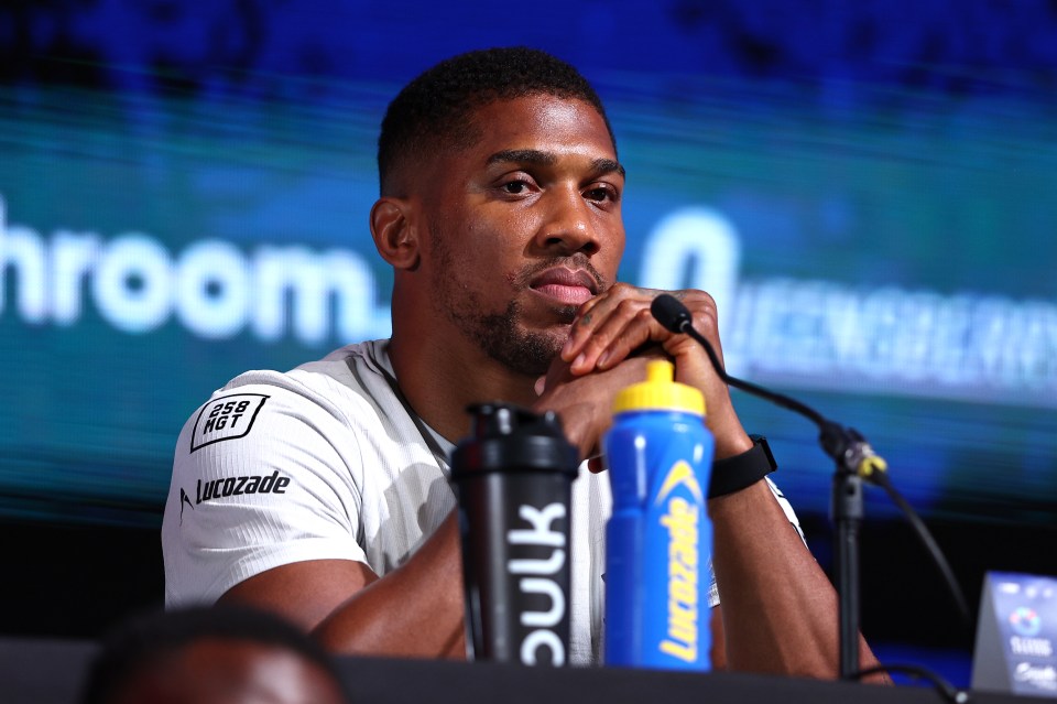 a man sits at a table with a bottle of bulk in front of him
