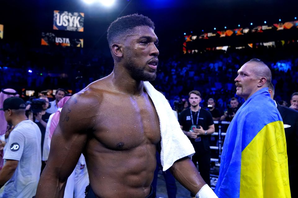 a man with a towel around his neck stands in front of a sign that says usvk