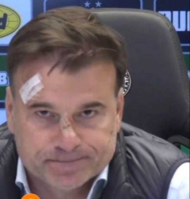 a man with a bandage on his forehead looks at the camera