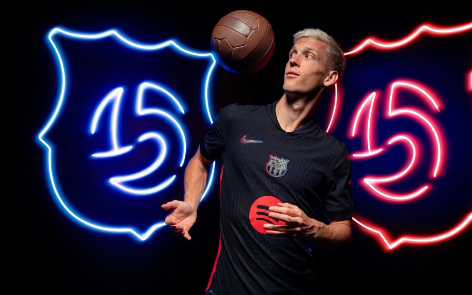 a man holding a soccer ball in front of a neon sign that says 15