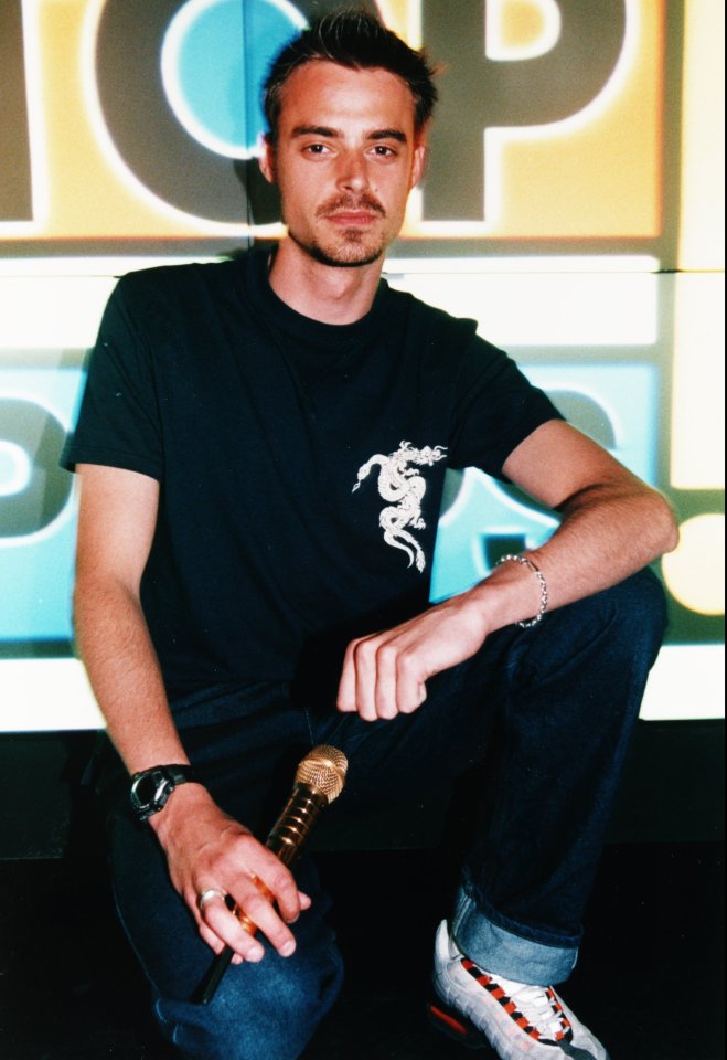 a man kneeling down holding a microphone in front of a sign that says icp