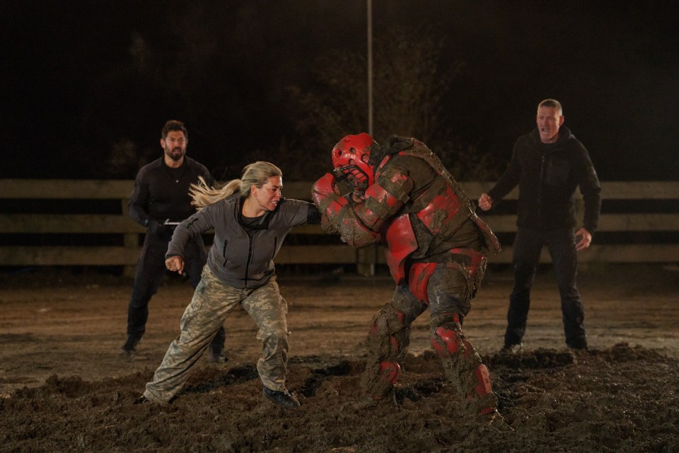 a woman in a military uniform is fighting a robot