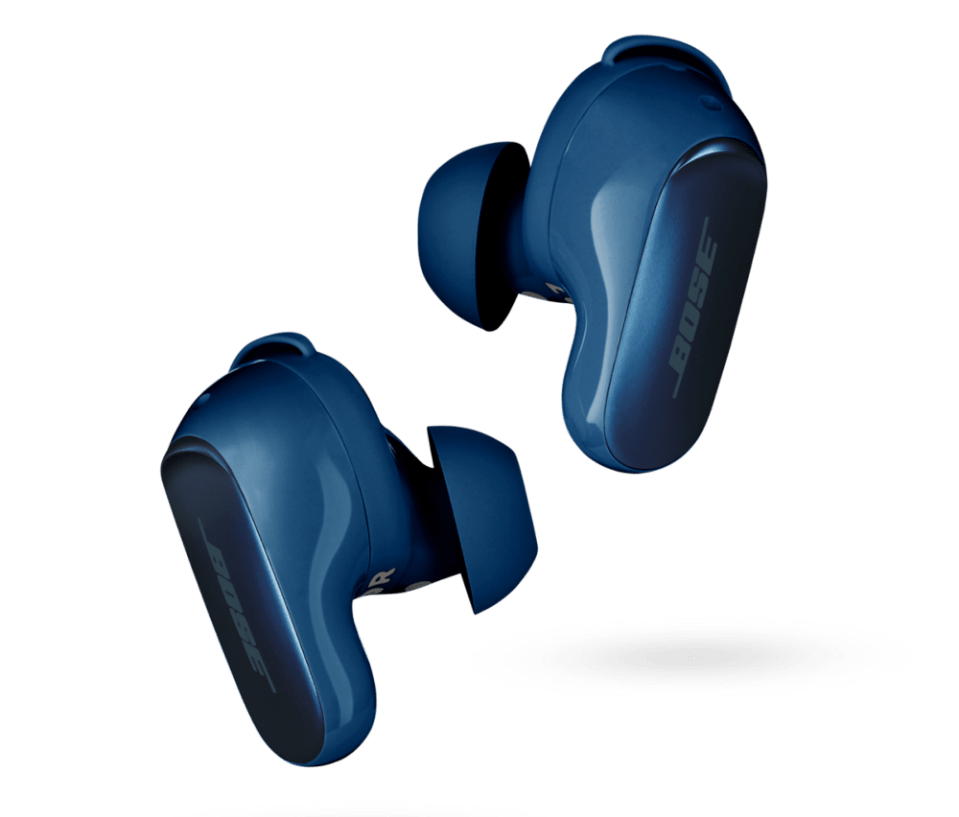 a pair of blue bose earbuds on a green background