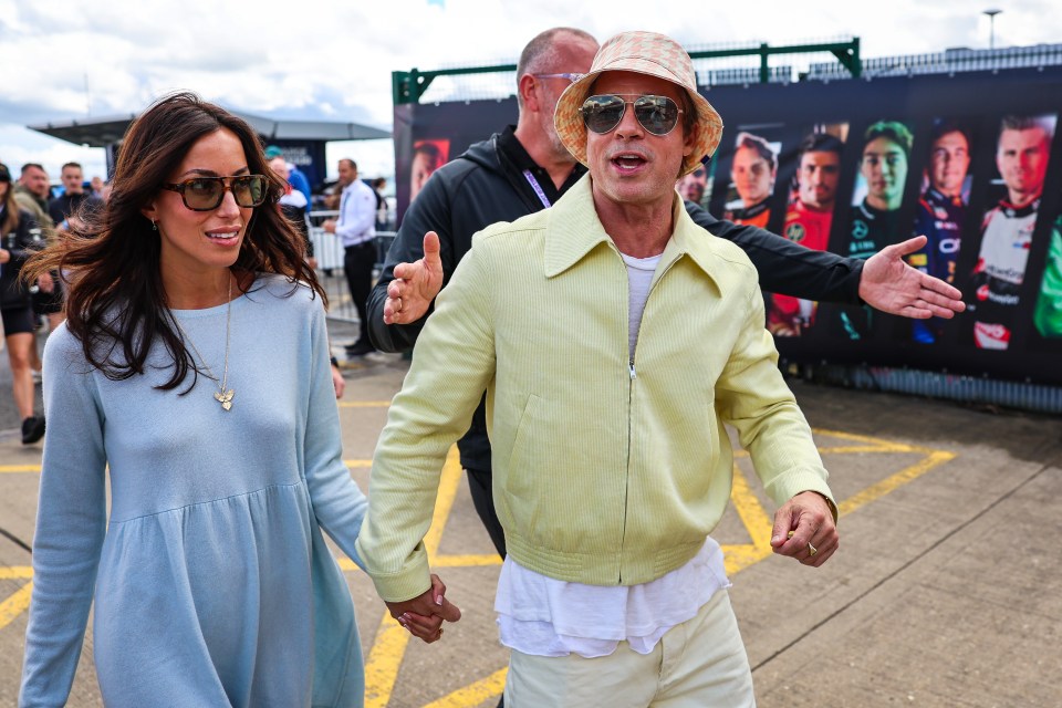 a man in a yellow jacket holds hands with a woman in a blue dress