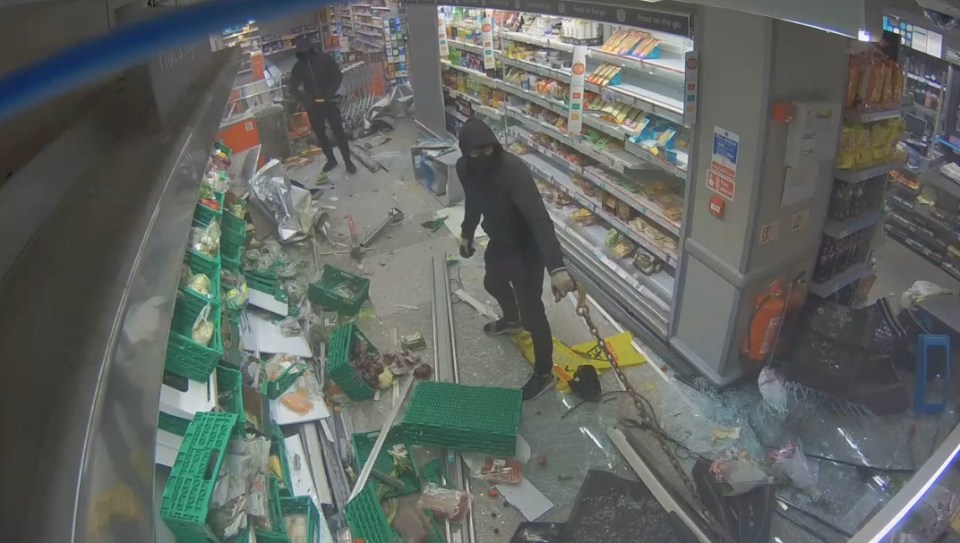 a man in a black mask stands in front of a broken refrigerator in a store