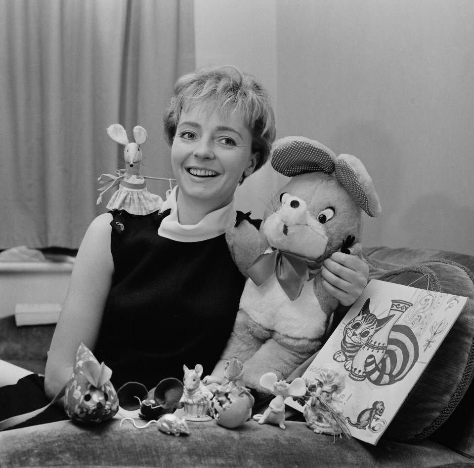 a black and white photo of a woman holding stuffed animals