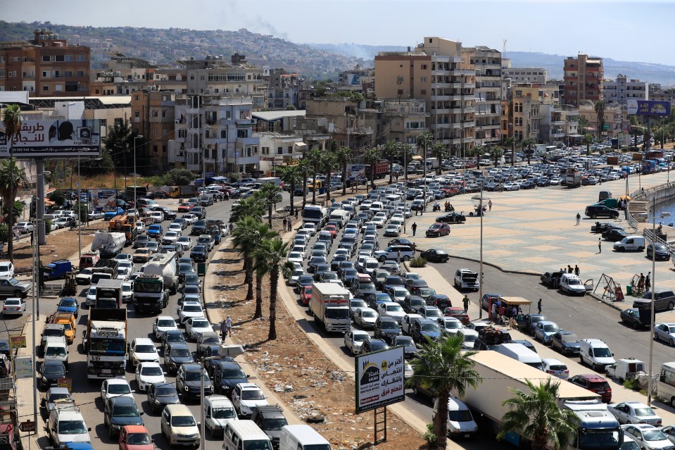 a busy city street with a billboard that says ' arabic ' on it