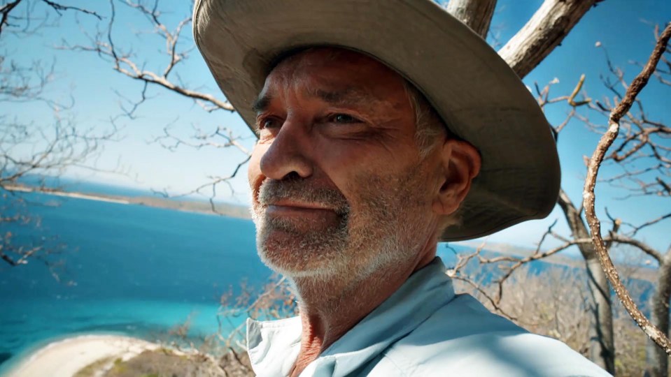 a man wearing a hat looks out over the ocean
