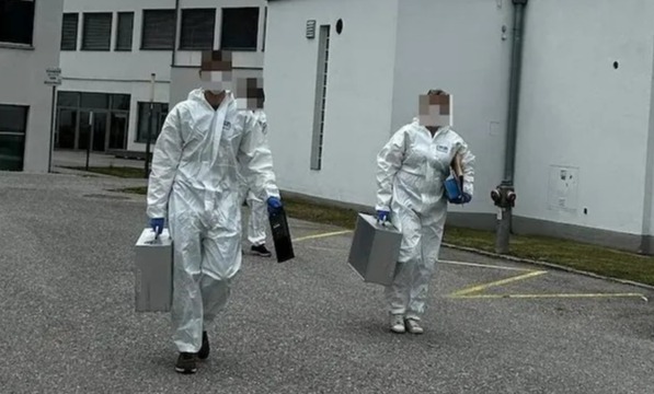 a man and a woman in protective suits are walking down a street
