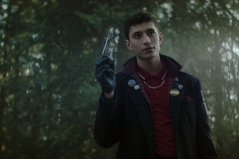 a man wearing a black jacket and a red shirt has a button on his jacket that says ' i love you '