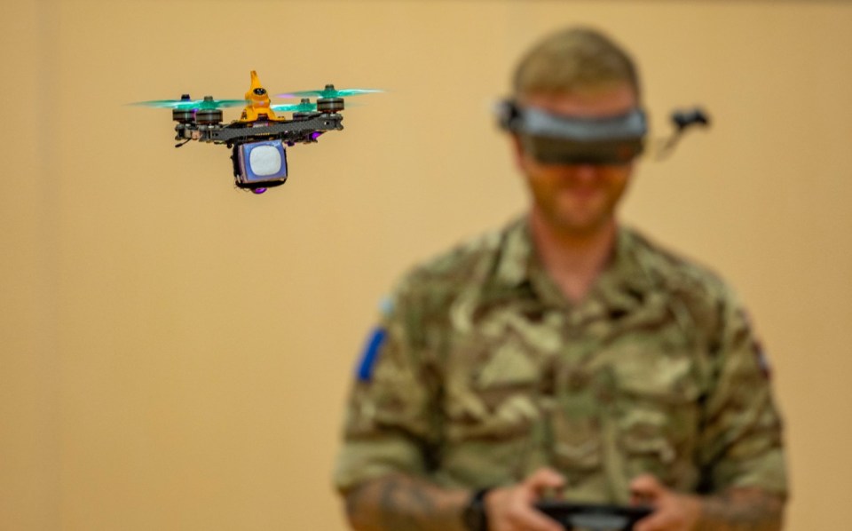a man in a military uniform is flying a small drone