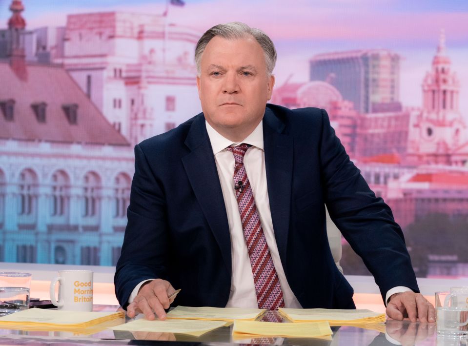 a man sitting at a desk with a mug that says good morning britain
